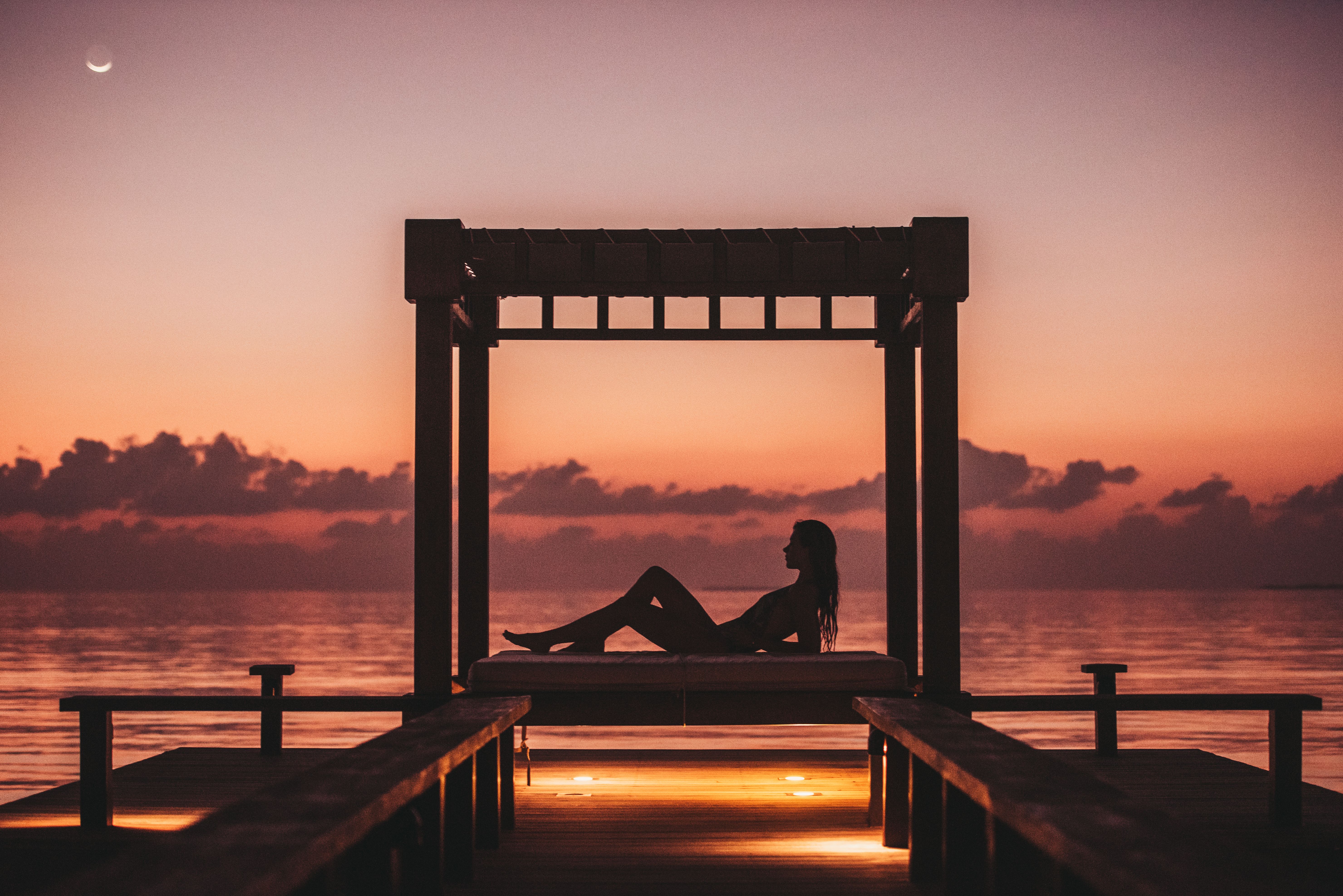 Traveler at rest, silhouetted at sunset